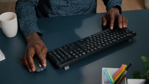 Top view of black african american person typing on PC keyboard, working from home. remote working computer user businessman freelance job in marketing and communication