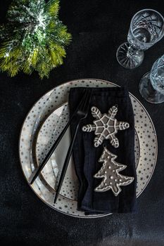 Holiday table setting for Christmas dinner on dark background