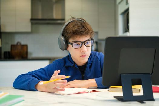 Distance learning online education. A schoolboy boy studies at home and does school homework. A home distance learning.