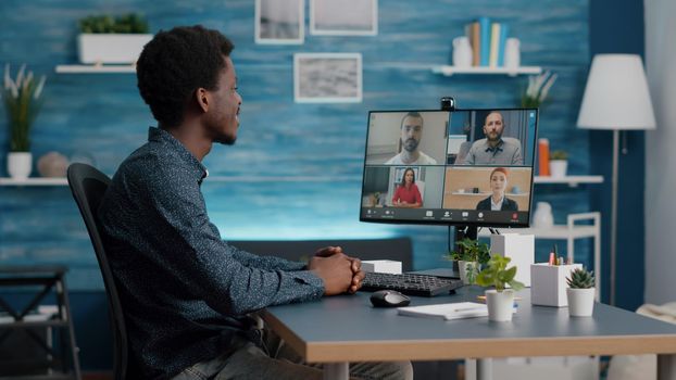 African american man on online internet conference chat with his coworkers, remote working from home, using teleconference web communication with webcam. Black guy distance technology talking