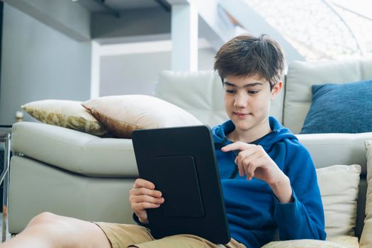 The boy using tablet to online communication at home