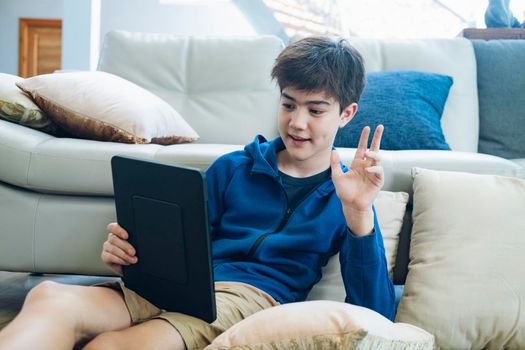 The boy using tablet to online communication at home