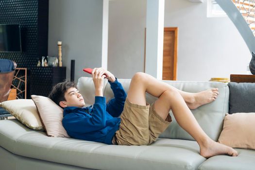 The boy playing online game on smartphone at home.