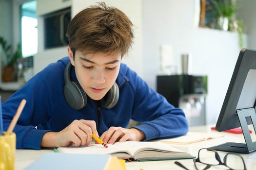 Distance learning online education. A schoolboy boy studies at home and does school homework. A home distance learning.