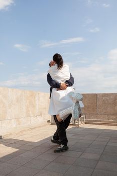 Haapy lovers dating at tower observation point spending romantic relationship anniversary together looking at panoramic view of metropolitan city. Happy couple hugging on building terrace