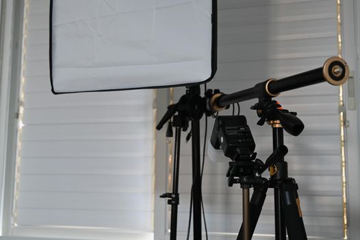 equipment for a home photo studio is located near a window with blinds