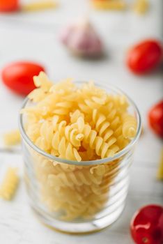 Italian fusilli pasta in glass bowl with cherry tomato and garlic