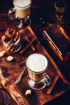 Irish coffee in drinking glass on wooden surface