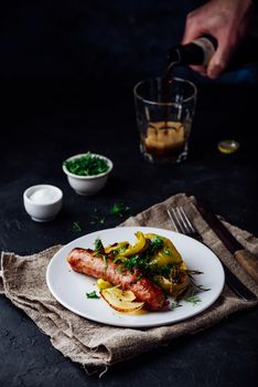 Oven baked pork sausage with green bell peppers, onion and herbs on white plate