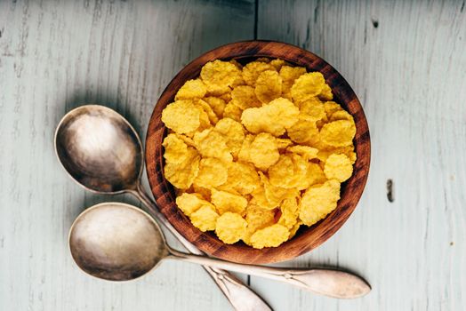 Rustic bowl of corn flakes over wooden surface. View from above