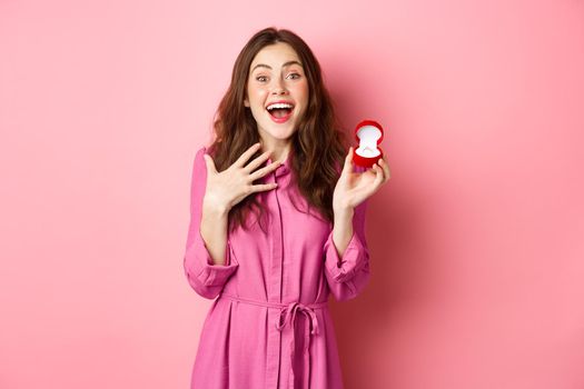 Excited young woman showing engagement ring, getting married, smiling happy, talking about wedding day, receive marriage proposal. Copy space.