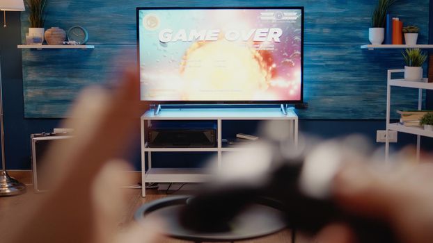 Close up of TV used for gaming concept at home. Video games on television console playing with wireless controller for fun activity. POV of hands holding joystick for digital simulator