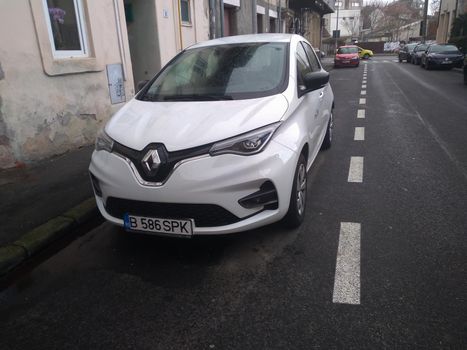 New electric car, white Spark Renault Zoe on street. Car sharing service in Bucharest, Romania, 2021