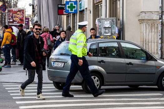 Police agent, Romanian Traffic Police (Politia Rutiera) directing traffic during  rush hour in downtown Bucharest, Romania, 2021