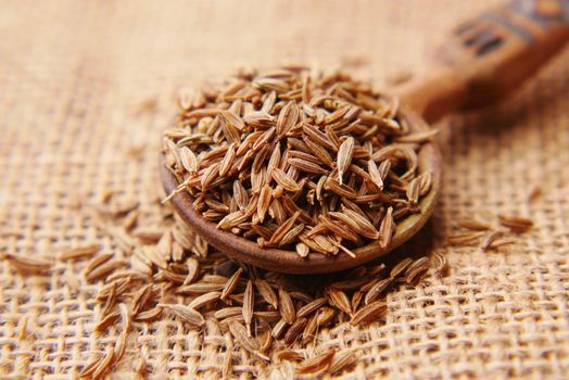 cumin seeds on spoon on table .