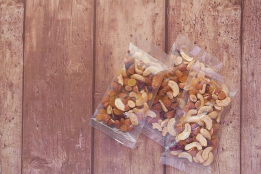 packet of mixed nuts on wooden background .