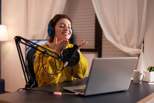 Vlogger speaking with follower on live using professional microphone wearing headphones. Creative online show On-air production internet broadcast host streaming live content, recording digital social.