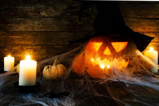 Halloween, decorations and holidays concept - pumpkins with spiders, web and candles
