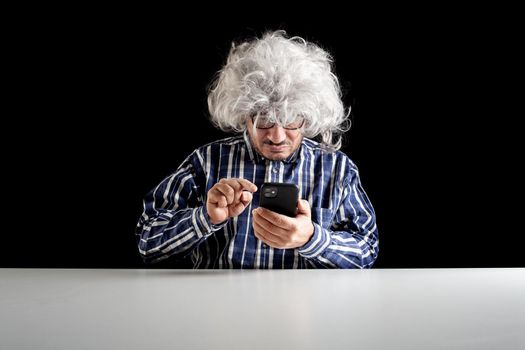 A senior man typical boomer curved on his smartphone typing text message