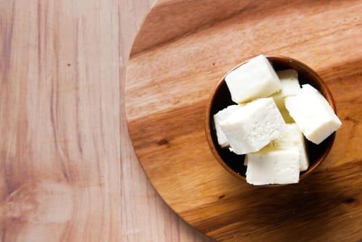 close up of fresh cheese in a bowl on table .