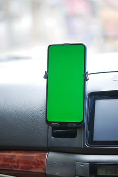 smart phone with green screen on car dashboard .