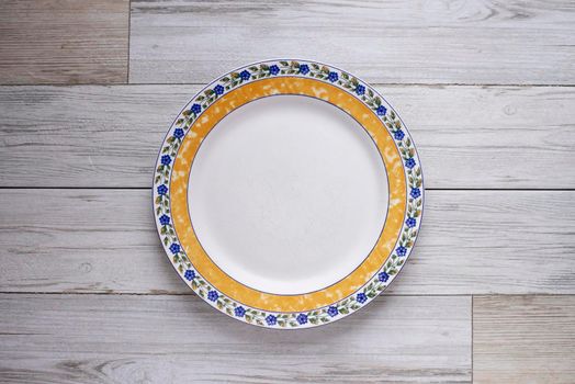 A ceramic dish (plate) on wooden table.Flat lay