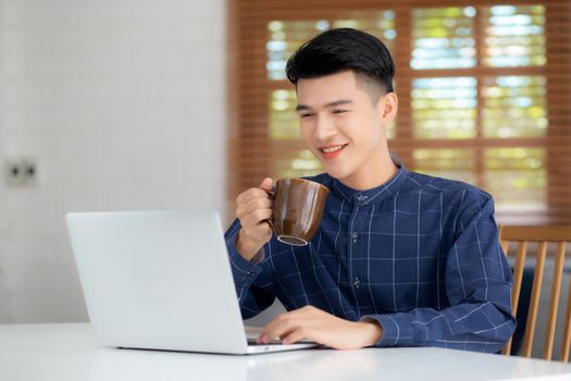 Young business man working from home with laptop computer on desk, freelance male sitting stay home using notebook for communication and relax on table, entrepreneur in startup business, new normal.