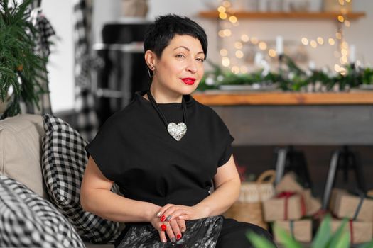 Portrait of a stylish tired adult woman, thinking about something while sitting on the couch.