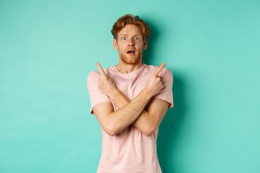Nervous guy with red hair staring indecisive, cross arms and pointing sideways, showing two variants with puzzled face, standing in t-shirt over mint background.