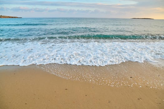 Seascape at sunrise, sea background, foam, sand dawn beach waves
