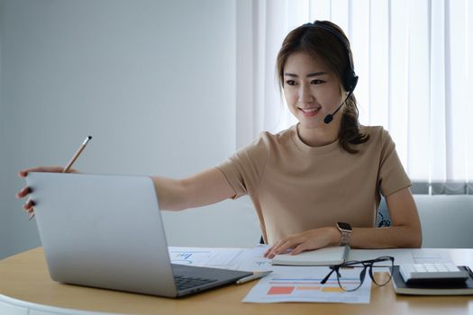 Businesswoman in having a video call on laptop while discussion with business partner during work from home. Support concept