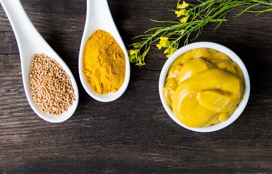 mustard sauce with its ingredients, turmeric, seeds and flowers