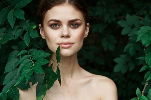 smiling woman skin care bare shoulders green leaves nature model. High quality photo