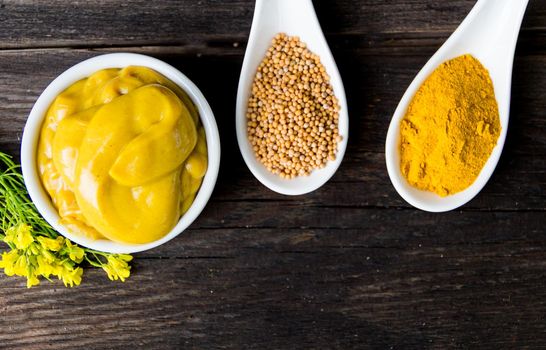 mustard sauce with its ingredients, turmeric, seeds and flowers