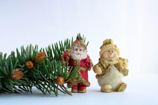 Santa Claus, a Snowman and a spruce branch with small young cones isolated on a white background.The concept of the New year and Christmas.