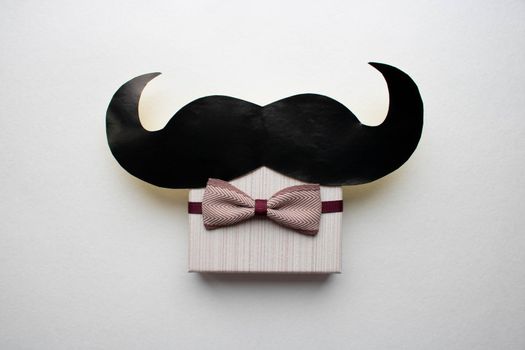 Gift box with a bow and a mustache.The concept of father's day.