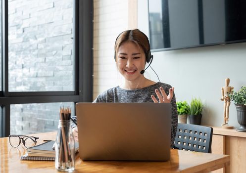 Cropped shot smiling asian woman freelancer wearing headset, communicating with client via video computer call. Millennial pleasant professional female tutor giving online language class.