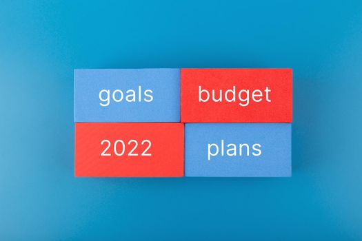 Business plan concept 2022. Budget, plan, goals 2022 written on colored rectangles on dark blue background. Financial goals for 2022