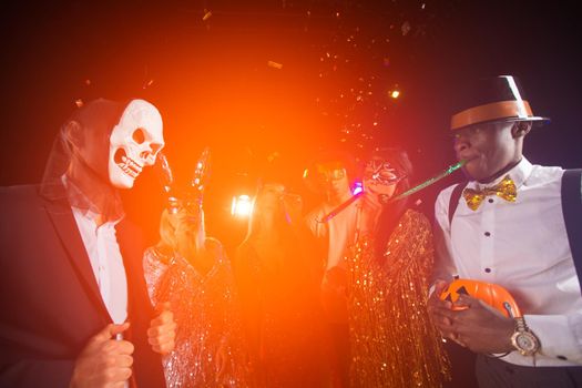 Happy people men and women mixed race dancing together on Halloween party