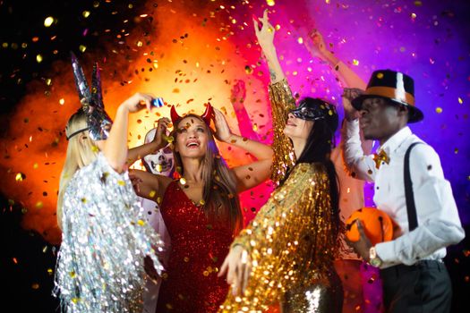 Happy people men and women mixed race dancing together on Halloween party