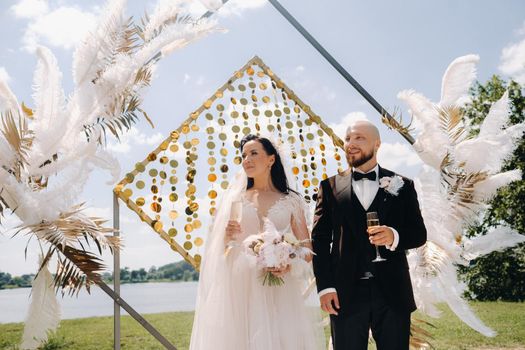 happy wedding couple near the wedding arch during the ceremony.