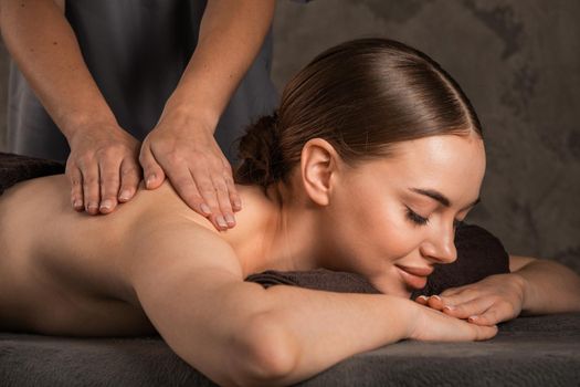 An attractive caucasian woman lying down on a massage bed at a spa