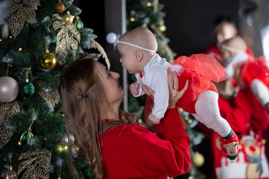 Mom and child at Christmas. A young woman with a newborn daughter on the background of Christmas interiors.