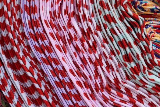 Detailed close up view on samples of cloth and fabrics in different colors found at a fabrics market.