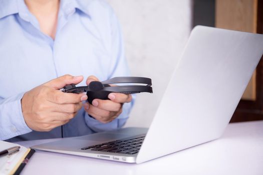 Hands of man holding headphone while laptop computer on desk, e-learning online, webinar for education and learning, digital seminar with notebook, video conference, headset for course multimedia.