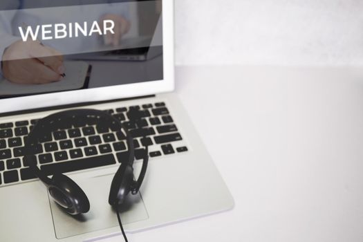 Laptop computer and headphone on desk, e-learning online, webinar for education and learning, seminar with notebook, video conference, headset for multimedia, course and classroom to internet.