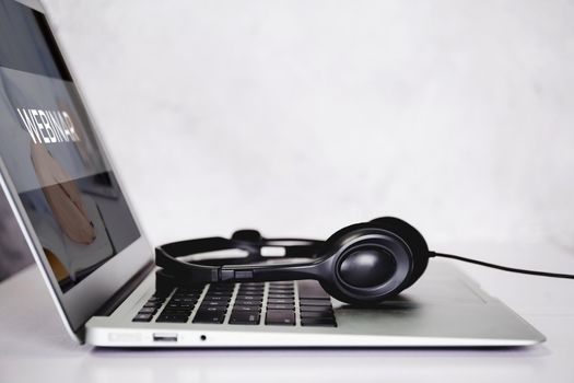 Laptop computer and headphone on desk, e-learning online, webinar for education and learning, seminar with notebook, video conference, headset for multimedia, course and classroom to internet.