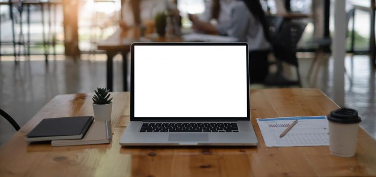 Mockup image of a laptop computer with white blank screen on wooden desk