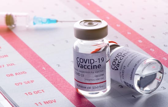 In the calendar, syringe with container of epidemic vaccine.