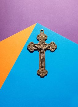 bronze cross on the colored table indoor closeup